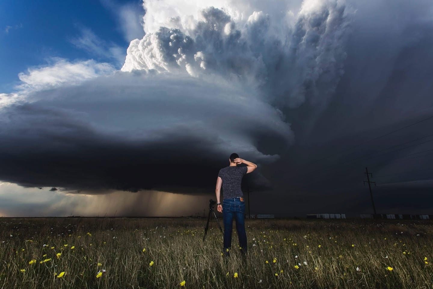 Daan watching a supercell thunderstorm develop over a Plains wildflower field